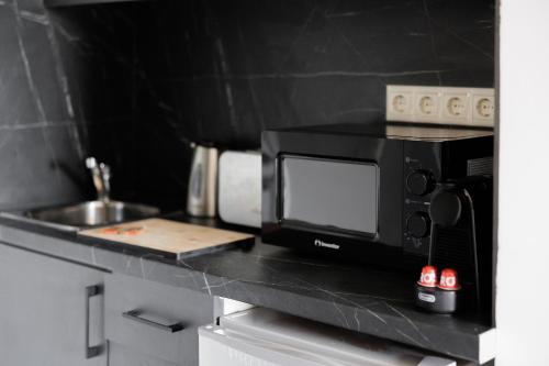 a microwave sitting on a counter in a kitchen at Ilios Properties - next to Gouvia Beach in Gouvia