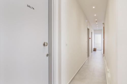 a hallway with white walls and a white floor at Ilios Properties - next to Gouvia Beach in Gouvia