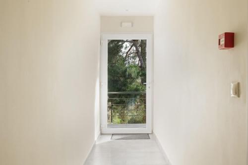 an open door in a white room with a window at Ilios Properties - next to Gouvia Beach in Gouvia