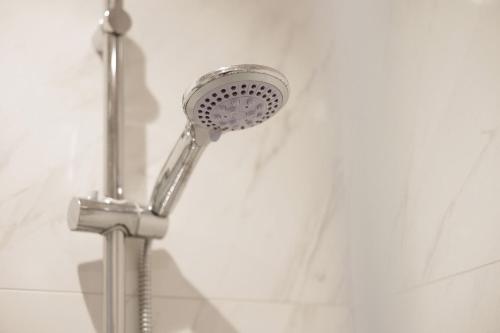 a shower with a shower head in a bathroom at Ilios Properties - next to Gouvia Beach in Gouvia