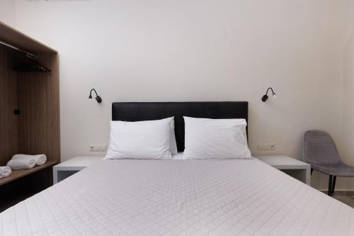 a bedroom with a bed with two white pillows at Ilios Properties - next to Gouvia Beach in Gouvia