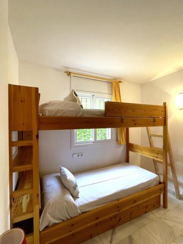 two bunk beds in a room with a window at Apartament Les Tonyines in Llança