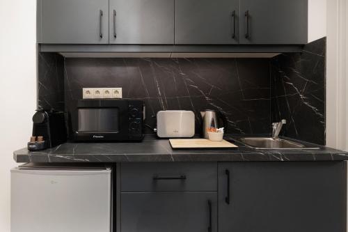 a kitchen counter with a microwave and a sink at Ilios Properties - next to Gouvia Beach in Gouvia