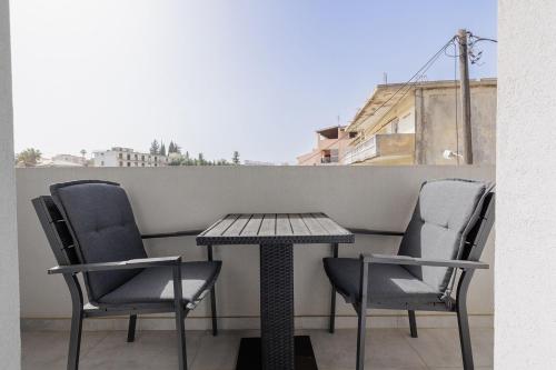 two chairs and a table on a balcony at Ilios Properties - next to Gouvia Beach in Gouvia