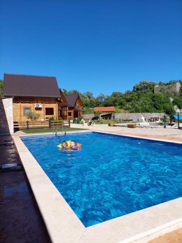 a person swimming in a swimming pool at Vinogradina Eco Vukčević in Virpazar