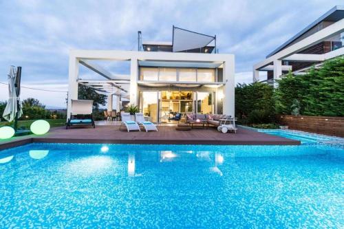 a house with a swimming pool in front of it at Island Villa Sani Sea View in Sani Beach