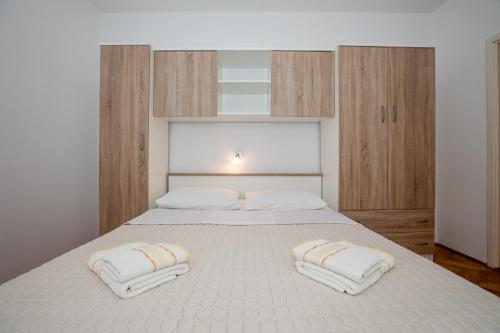 a bedroom with a bed with two pillows on it at Apartmani Zdenka in Rab