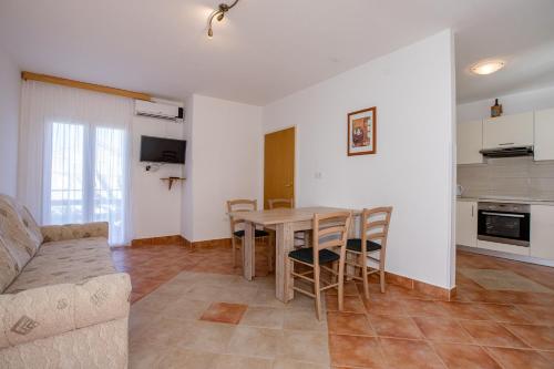 a living room with a table and chairs and a couch at Apartmani Zdenka in Rab