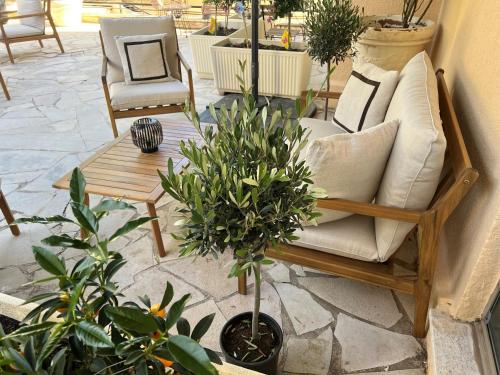 um pátio com um sofá, uma mesa e plantas em Hôtel Gallia Cannes em Cannes