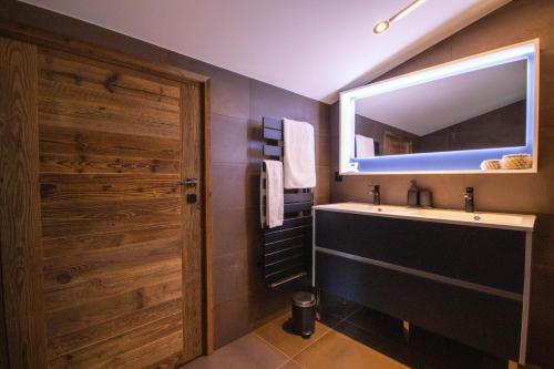 une salle de bain avec un lavabo et un miroir dans l'établissement Smartstay La Nuit Etoilee - Megeve, à Demi-Quartier