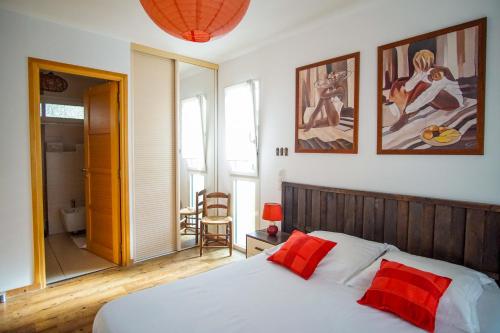 - une chambre avec un lit doté d'oreillers rouges dans l'établissement -COLINE- Charmante maison familiale proche plage, à Concarneau