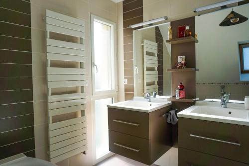 une salle de bain avec deux lavabos et un miroir dans l'établissement -COLINE- Charmante maison familiale proche plage, à Concarneau