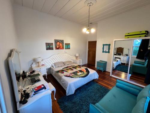 a bedroom with a bed and a couch and a mirror at La Casa Bonita Auckland in Auckland