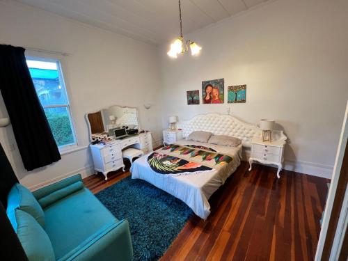 a bedroom with a bed and a chair and a desk at La Casa Bonita Auckland in Auckland