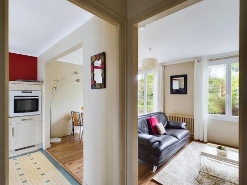 a living room with a couch and a kitchen at -HARES- Maison authentique avec jardin in Trégunc