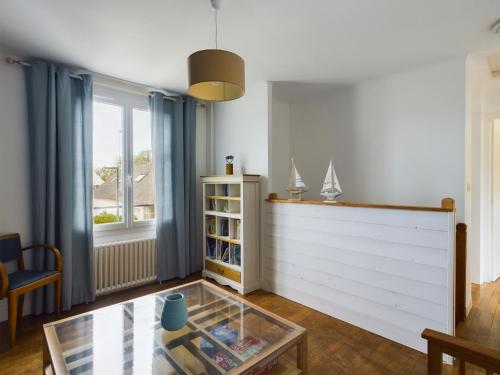 a living room with a glass table and a window at -HARES- Maison authentique avec jardin in Trégunc