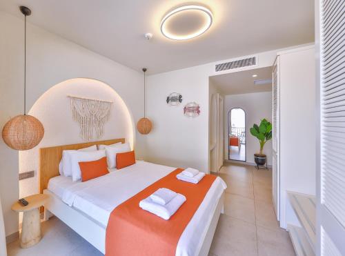 a bedroom with a large bed with orange and white pillows at Pastel Rooms in Kas