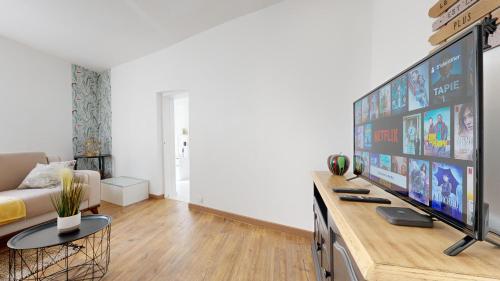 a living room with a large flat screen tv at Cosy et Chic Centre Ville in Tulle