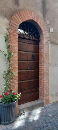 a wooden door in a brick wall with a plant at Casa Vincenti in Orvieto