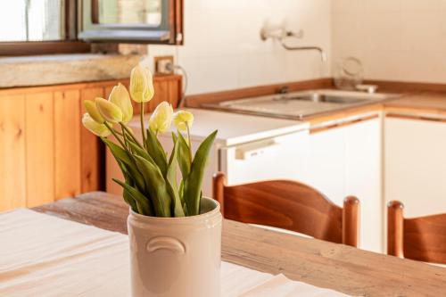 a vase with flowers on a table in a kitchen at Il Giardino Segreto in Barzio