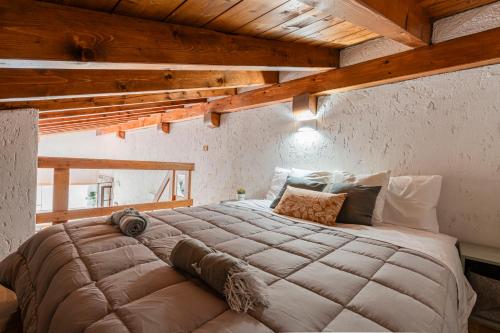 a large bed in a room with wooden ceilings at Il Giardino Segreto in Barzio