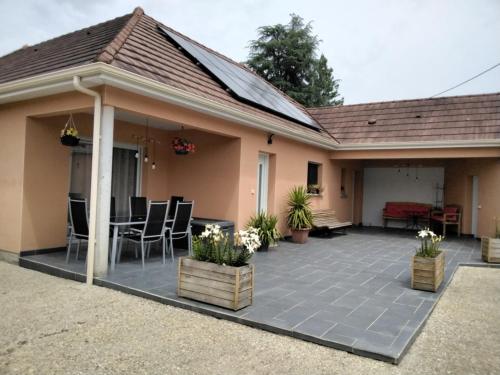 a house with a patio with chairs and a table at La pause ô logis gourmande in Navarrenx