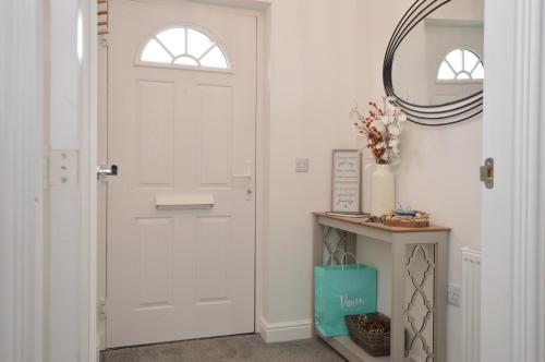 a hallway with a white door and a mirror at Kilin in Lochgilphead