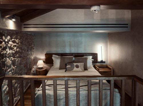 a bedroom with a large bed with a wooden rail at KaSeas Boutique Hotel in Gerolimenas