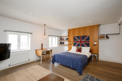 a bedroom with a bed and a tv and a desk at Stylish Fitzrovia Studios W1 in London