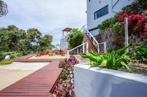 a wooden walkway next to a building with flowers at Naudicals Dune in Chefe Imala