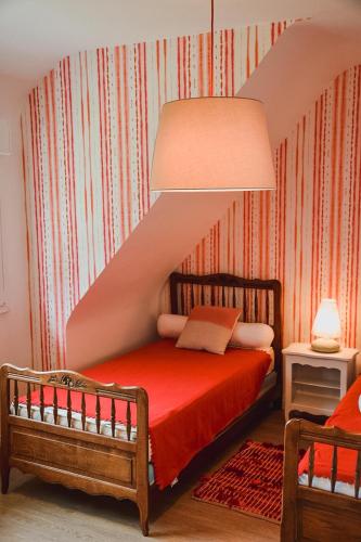 a bedroom with a red bed with a staircase at -LES LUTINS- Charmante maison les pieds dans l eau in Concarneau