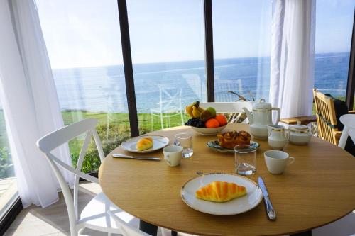 une table en bois avec des assiettes de nourriture au-dessus dans l'établissement -AZEL- Maison surplombant l ocean, à Névez