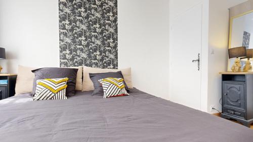 a bedroom with a large bed with two pillows at Cosy et Chic Centre Ville in Tulle