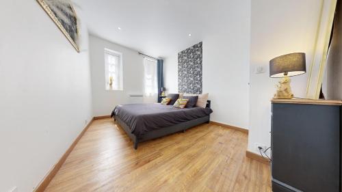 a bedroom with a bed and a couch in a room at Cosy et Chic Centre Ville in Tulle