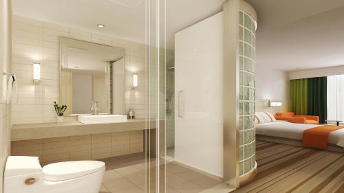 a bathroom with a toilet and a sink and a bed at Holiday Inn Express Changzhou Lanling, an IHG Hotel in Changzhou
