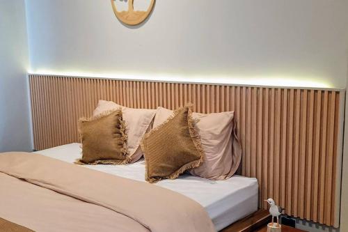 a bed with pillows on it in a room at Alodia Villa with pool & kitchen in Sanur