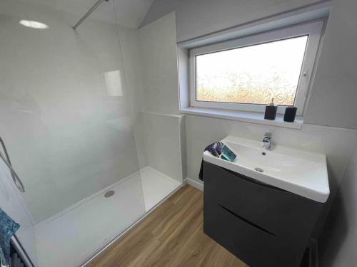 a white bathroom with a sink and a window at LeeVal Detached House parking in Stockton-on-Tees