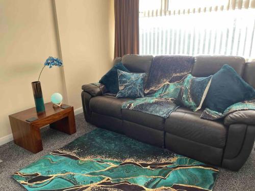 a living room with a couch and a table at LeeVal Detached House parking in Stockton-on-Tees