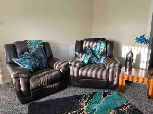 a living room with two leather chairs and a table at LeeVal Detached House parking in Stockton-on-Tees