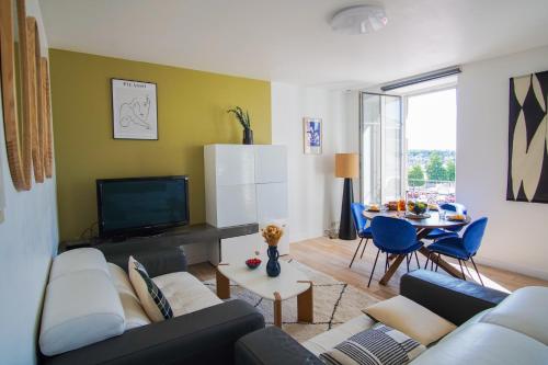 un salon avec un canapé, une télévision et une table dans l'établissement -Zely- Elegant T3 au coeur de Concarneau, à Concarneau