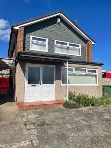 a brick house with a white door and windows at LeeVal Detached House parking in Stockton-on-Tees