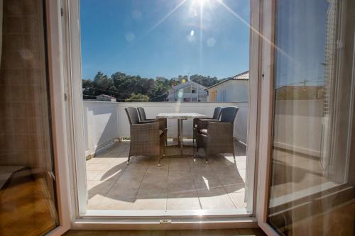 a patio with a table and chairs on a balcony at Apartmani Zdenka in Rab