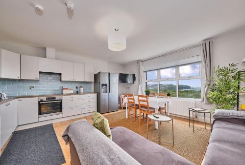 a kitchen and living room with a couch and a table at Dunluce Park 6 - Portrush by the Sea in Portrush