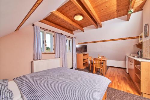 a bedroom with a bed and a kitchen with a table at Ubytování u Chladů in Horská Kvilda
