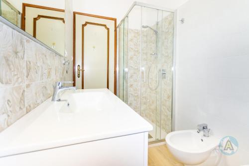 um banheiro branco com pia e chuveiro em Le Palme 50a em Silvi Paese