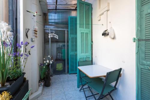 un petit patio avec des volets verts et une table et des chaises dans l'établissement PORT CARNOT AP4405 By Riviera Holiday Homes, à Nice
