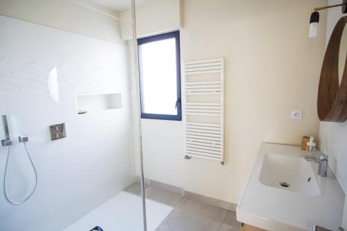 a white bathroom with a sink and a shower at -TY AR MOR- Belle maison corniche a 150m de la mer in Concarneau