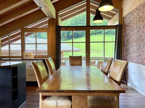 a dining room with a wooden table and chairs at Alpenlodge Charivari - SommerBergBahn unlimited kostenlos in Oberstdorf