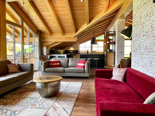 a living room with red couches and a table at Alpenlodge Charivari - SommerBergBahn unlimited kostenlos in Oberstdorf