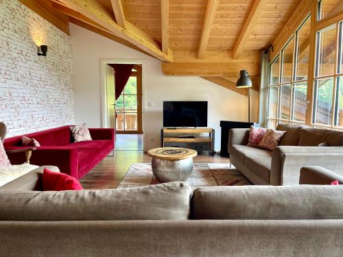 a living room with couches and a flat screen tv at Alpenlodge Charivari - SommerBergBahn unlimited kostenlos in Oberstdorf